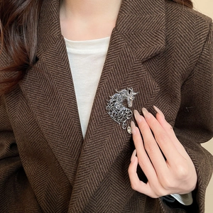Detail of a sparkling horse brooch with purple crystals on a brown tweed suit jacket