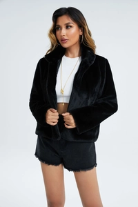 Gros plan sur la texture d'une veste noire en fausse fourrure à manches longues