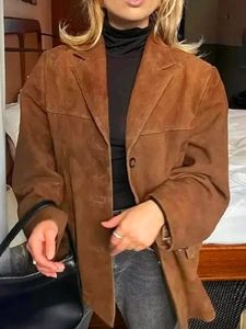 Détail macro d'une veste en daim marron avec revers et boutons simples vintage
