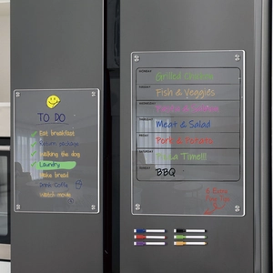 Clear magnetic acrylic weekly planner and to-do list boards on a dark grey refrigerator