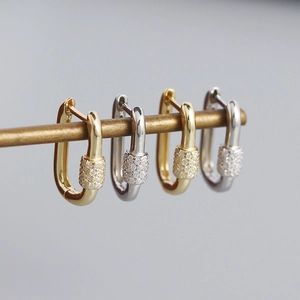 U-shaped s925 silver pave earrings in gold and silver finish on a brass rod