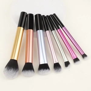 Detailierte Anordnung von 7 bunten Metallic-Make-up-Pinseln auf weißem Rundständer