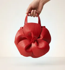 Detailed view of red petal-shaped tote bag with 3D floral texture and beaded center