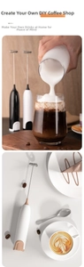 Detail of handheld electric milk frother with stainless steel whisk and creamy foam