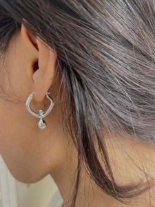 Elegant 925 silver hoop earrings featuring a high-polished teardrop pendant on a female model