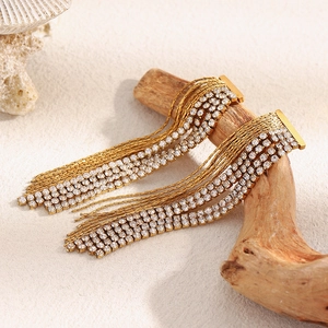 Macro detail of 18K gold-plated tassel earrings with sparkling zircon rhinestones