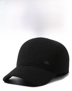 Detail showing the stiff brim and mountain metal logo on the side of the black baseball cap