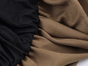 Detailed close-up of heavy twill fabric texture in black and khaki colors for midi skirts