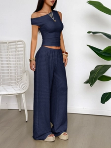Detail of navy blue two-piece set featuring textured fabric and wide-leg trousers