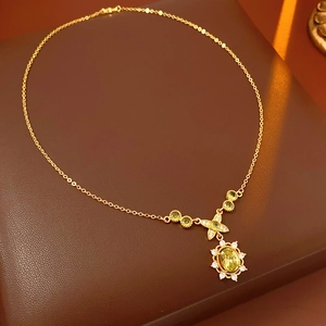 Gros plan d'un collier vintage doré avec pierre verte ovale et zircons sur du cuir