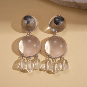 Détail macro de boucles d'oreilles en résine transparente avec couches géométriques