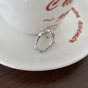Close-up of irregular liquid metal style 925 sterling silver open ring on white tray