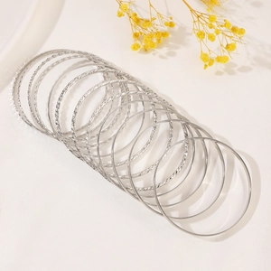 Detail of 12pcs silver alloy bangles set with polished and twisted rope textures