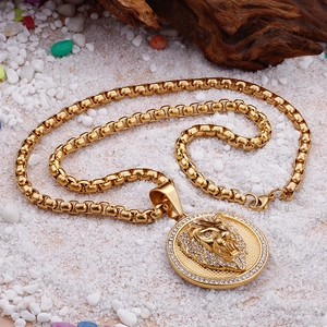 Macro shot of gold lion head pendant with sparkling rhinestones on box chain