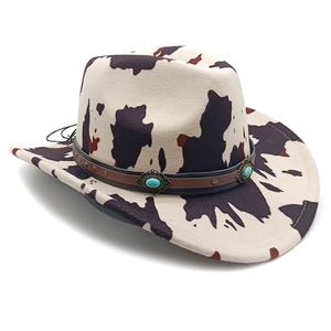 Detail of cow print cowboy hat with studded leather band and turquoise stone accents