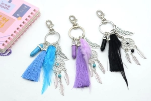 Detail of dreamcatcher keychains featuring turquoise stones and colorful yarn tassels