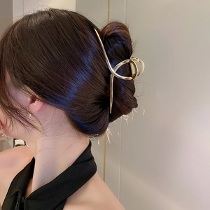 Détail d'une grande pince à cheveux en métal doré avec diamants et perles sur le modèle