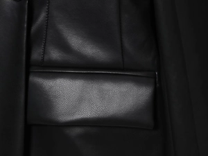 Close-up detail of pocket flap stitching and texture on black PU leather blazer jacket