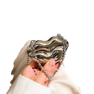 Silver lip-shaped metal mini bag with beaded chain strap displayed in hand