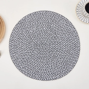Detailed view of the black and white woven texture on a round heat-resistant placemat