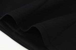 Detailed macro view of the premium black knit fabric texture on a slim-fit blazer jacket