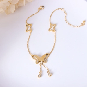 Elegant 18k gold butterfly anklet with tassel rhinestone charms on white background