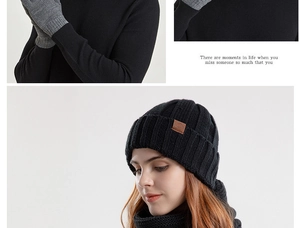 Detail of winter knitted hat with brown leather patch, grey gloves and warm scarf set