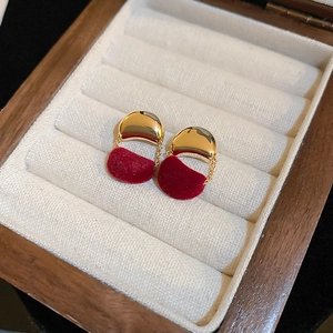 Close-up of elegant red velvet petal stud earrings in a wooden jewelry box