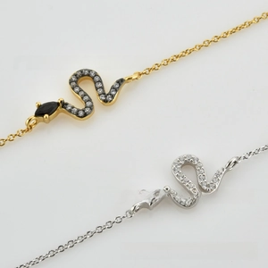 Detail of gold and silver snake chain bracelets with sparkling zircon pave settings
