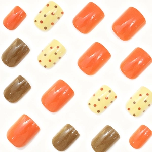 Chic autumn press-on nails featuring maple orange, brown, and polka dot square designs