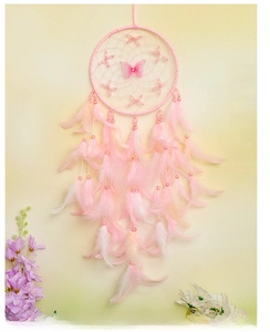 Close-up of pink handmade dreamcatcher with delicate feathers and butterfly charm