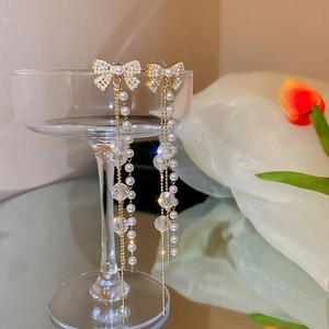 Boucles d'oreilles nœud doré avec de longs glands en perles et perles de cristal