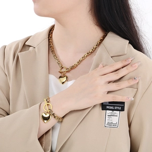Golden chunky chain jewelry set with heart pendant and OT buckle on model