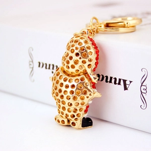 Golden hollow metal Santa keychain with red rhinestones on a white background