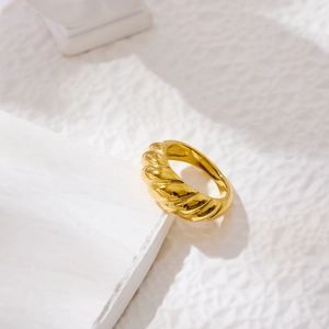 Macro shot of gold-plated croissant ring featuring a vintage twisted rope design texture