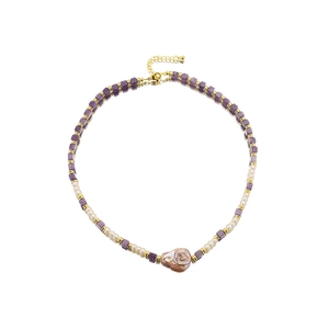 Vintage Baroque pearl necklace with purple amethyst beads and gold accents on white background