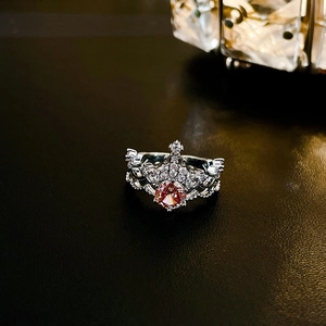 Detail of silver crown ring featuring a pink pear-cut gemstone and white pavé zircons