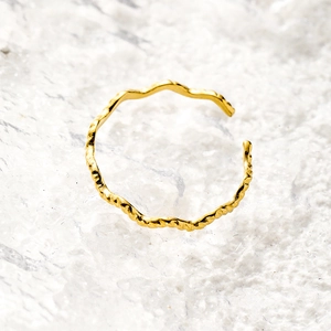 Macro shot of gold-plated 18K stainless steel open ring with irregular hammered texture