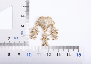 Dettaglio del ciondolo a cuore placcato oro 18k con tre figure familiari largo 3,5 cm