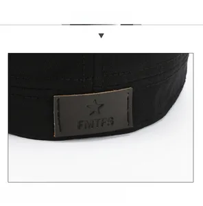 Detail shot of black cotton canvas military cap with star-embossed brown leather patch