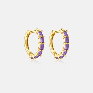 Detalle de pendientes de aro dorados con fila de circonitas moradas corte baguette