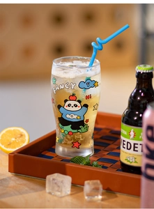 Detail view of a large glass beer mug featuring cute cartoon panda and fancy text prints