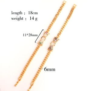 Macro shot of gold-plated Cuban chain featuring colorful zircon leopard head details
