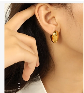 Detailaufnahme eines minimalistischen goldenen Tropfen-Ohrrings, getragen von einem Model