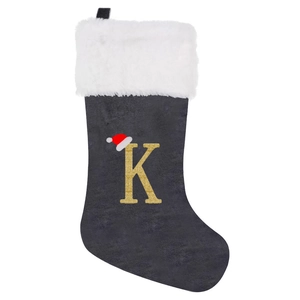 Detail of black Christmas stocking with white faux fur cuff and gold glitter letter K