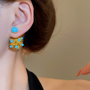 Detailed view of floral cluster earrings with blue stones on a model side profile