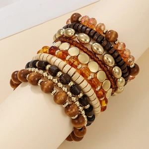 Detail of bohemian multilayered stackable bracelet with wood beads and gold metal accents