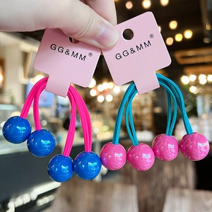 Detail of colorful hair ties with smooth blue and pink beads on branded display card