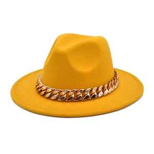 Detail of yellow wool felt fedora featuring a bold gold metal chain link decoration