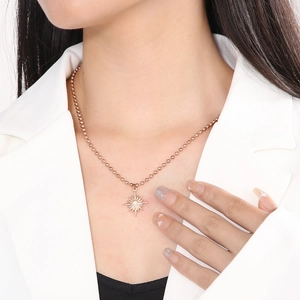 Gros plan du pendentif étoile en or rose avec chaîne à billes sur un mannequin